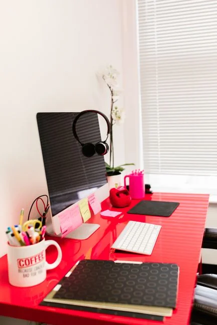 A woman reviewing a brand strategy document on a clipboard beside a laptop in an office environment.